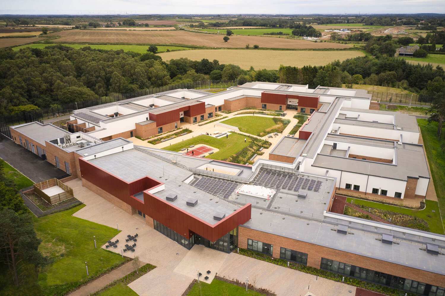 Large-scale facility with integrated solar panels, green infrastructure, and sustainable building performance design