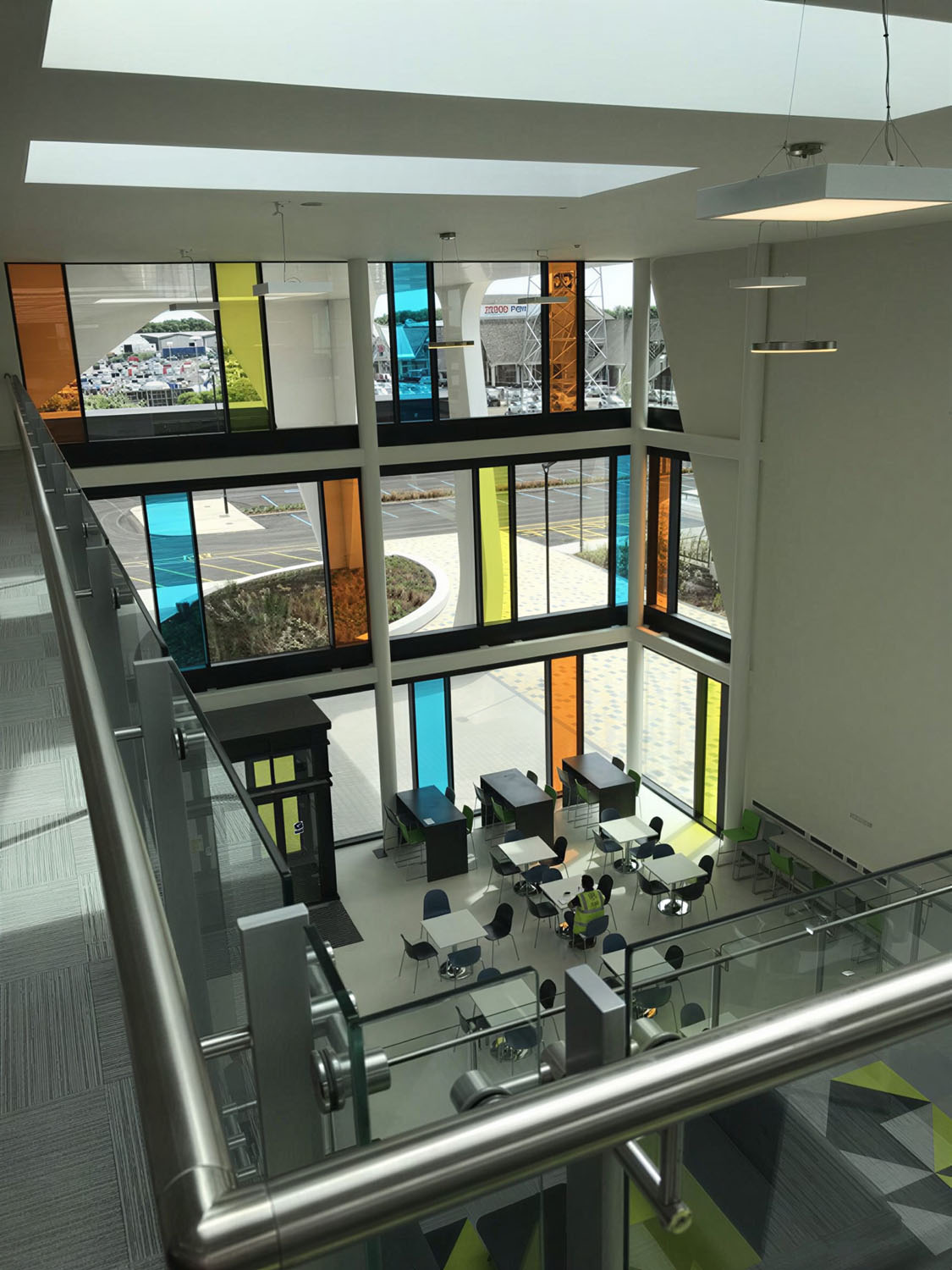 West Dicision HQ internal view looking down from 1st floor seeing office space and coloured galzing panels
